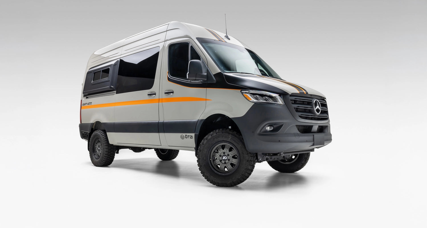 Camper van lounge space with bench seating, lagoon table, and laptop for remote work on the road