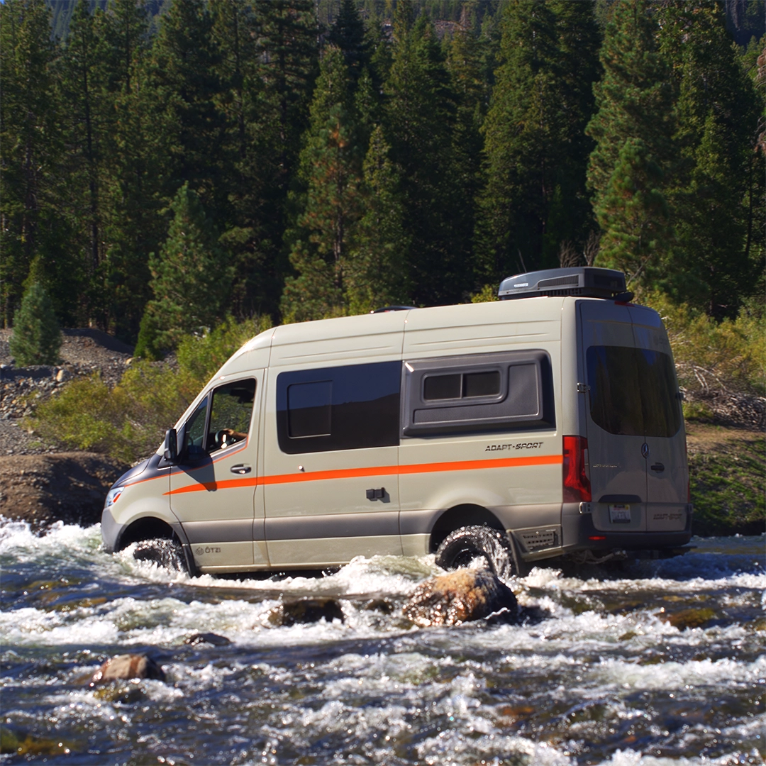 Off‑grid camper van at sunrise, solar panels deployed and camp kitchen ready for vanlife breakfast