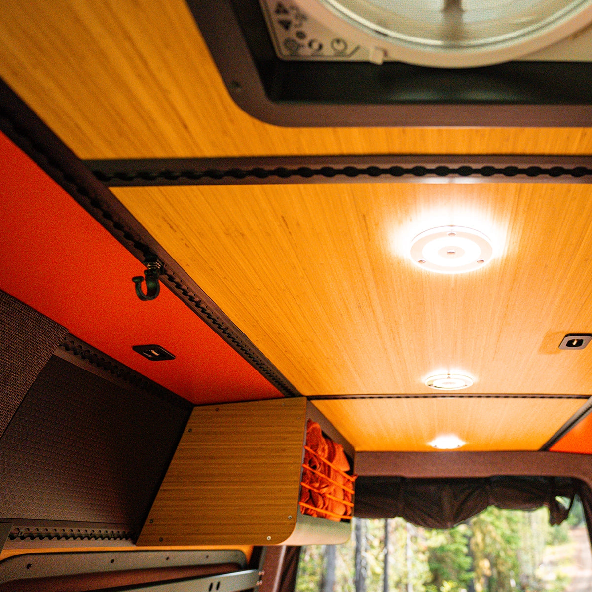 Adventure van interior garage under the bed with bikes, recovery gear, and camping equipment neatly organized