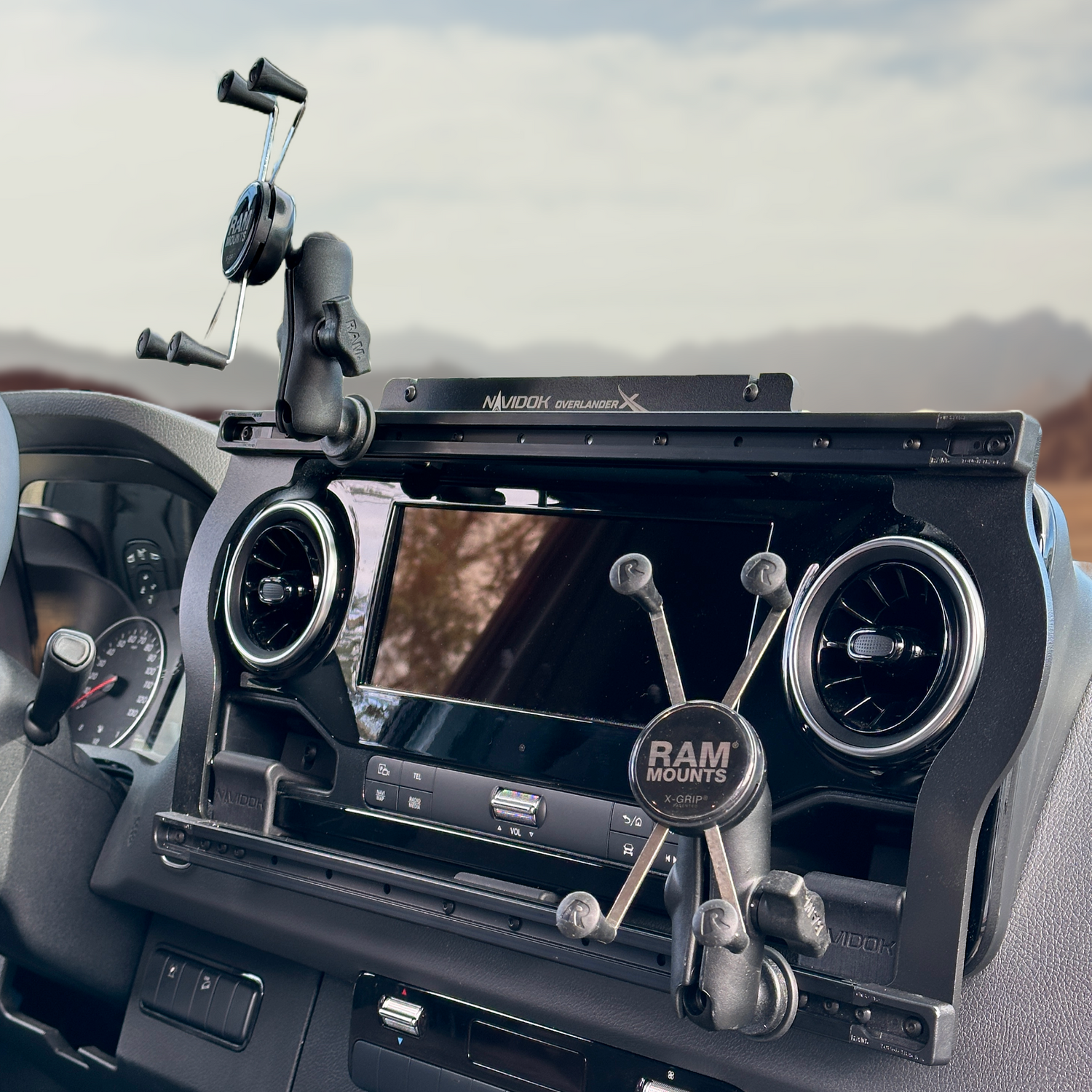 Vehicle dashboard phone mount system with adjustable arms and suction cup base installed.