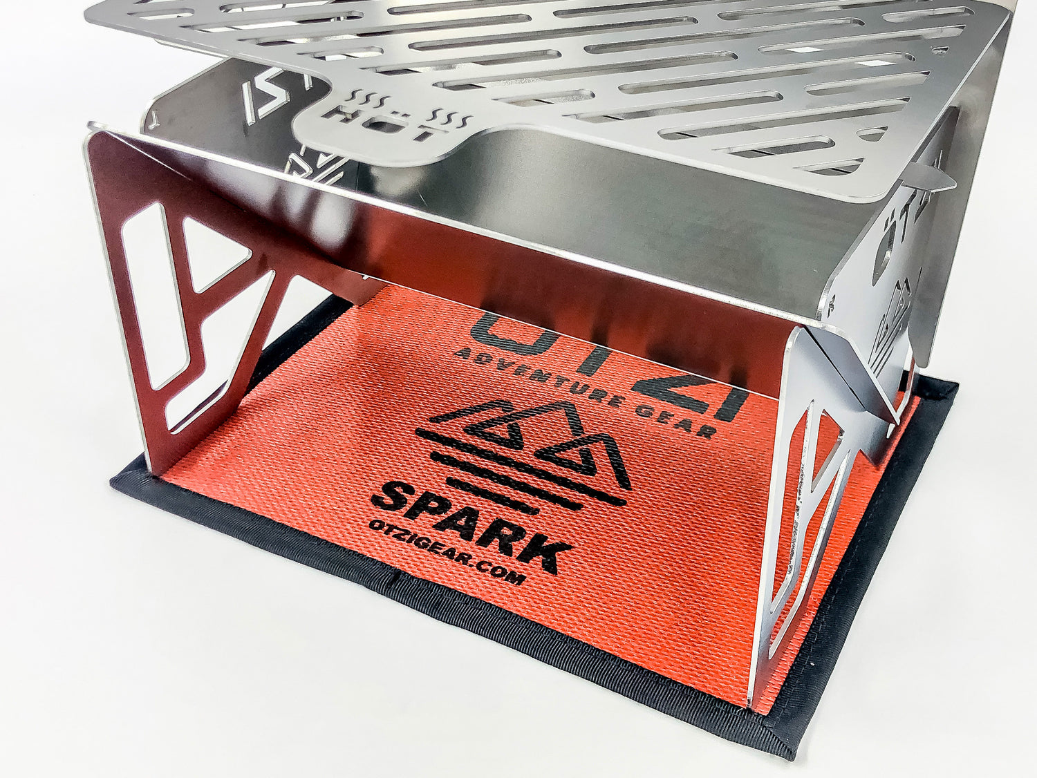 Stainless steel portable camping stove on red OTZI Gear mat