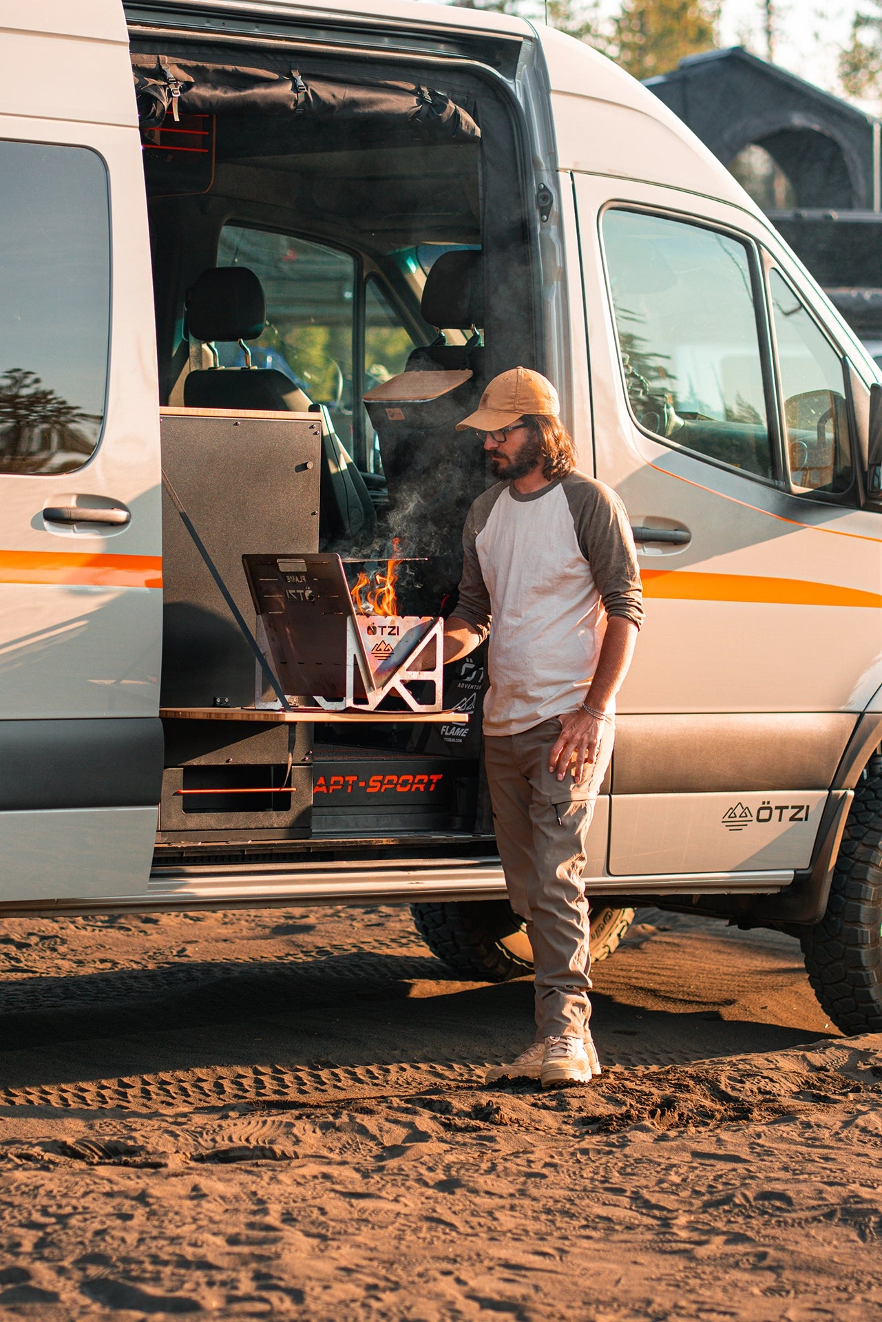 Outdoor adventure van kitchen like vannon vans with rear slide‑out stove and storage drawers at forest campsite