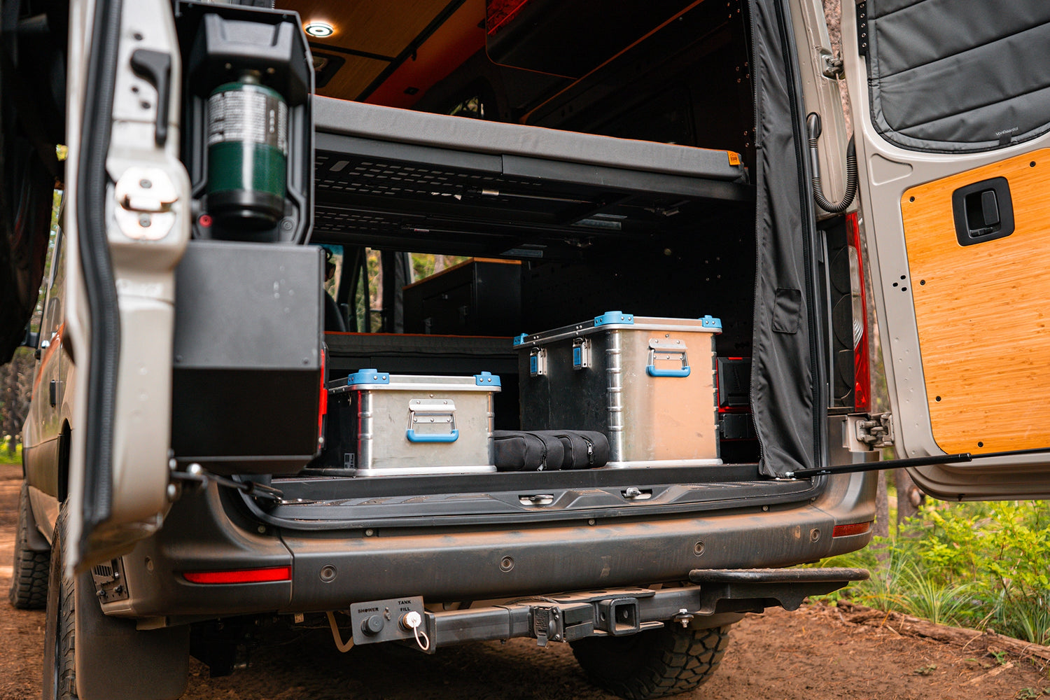 Cozy off‑road camper van interior with raised bed and storage, designed for full‑time vanlife