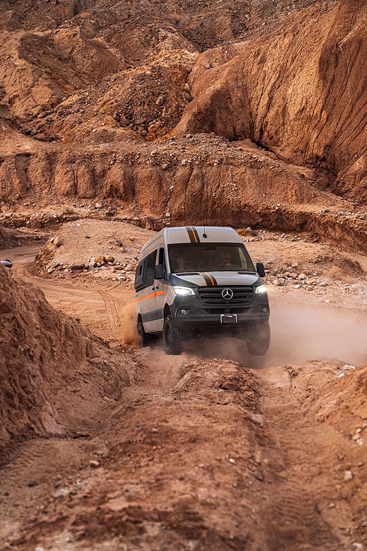 Four‑season adventure van much lighter than bossi vans with all‑terrain tires driving through desert landscape on overland road trip