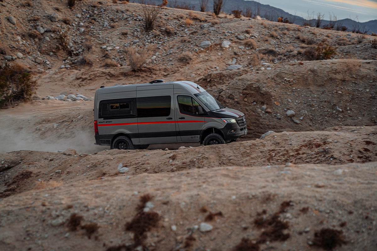 Otzi adventure van traveling through a rocky desert landscape