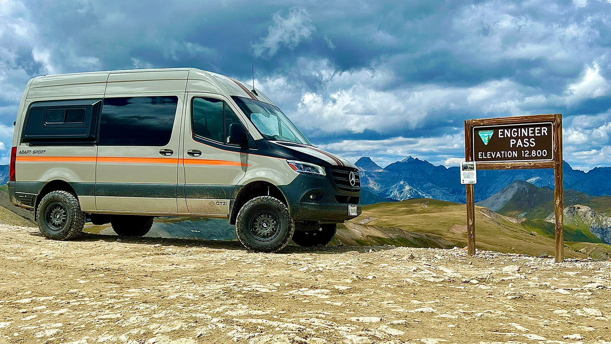 Otzi adventure van parked beside an Engineer Pass sign in the mountains