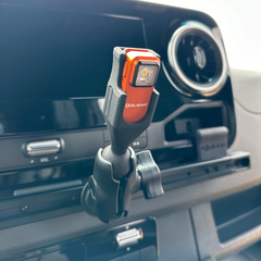 Compact red Olight flashlight mounted on a car dashboard.
