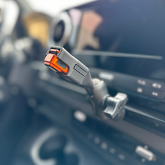Close-up of a car seat belt buckle with an orange release button