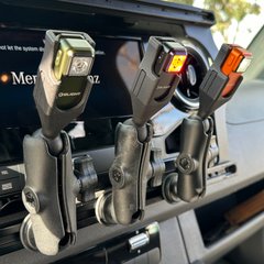 Three compact rechargeable flashlights mounted on a car dashboard rail system.