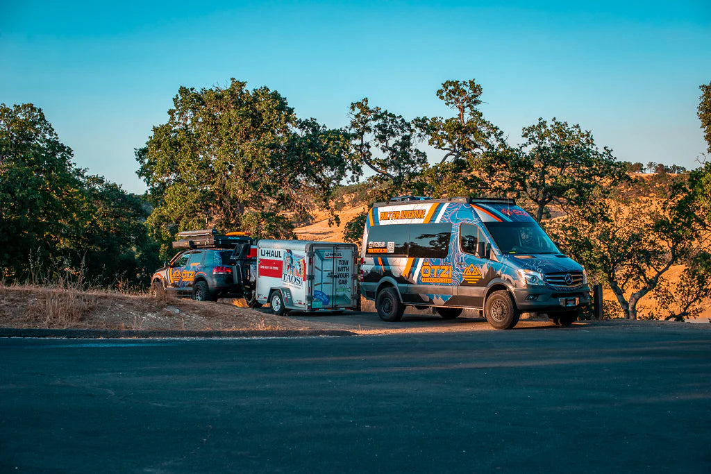 An adventure van and overland rig parked at a camp site 