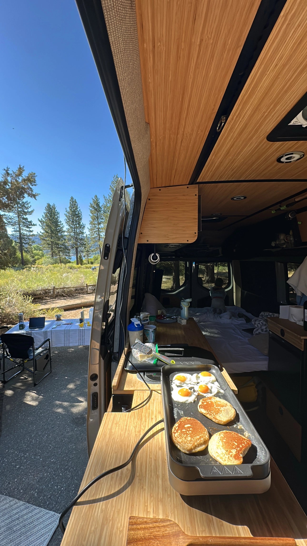 Luxury off‑road camper van interior featuring wood cabinets and a vanlife‑ready workspace