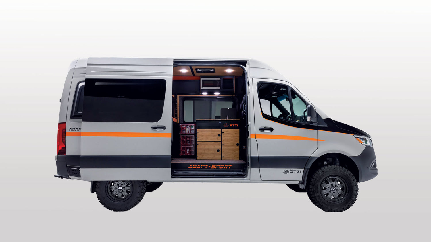 Off‑road adventure van interior with swivel seats and folding table set up as a mobile vanlife office