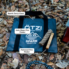 Outdoor fire-starting kit with spark carry case, jute rope tinder, and fatwood fire stick on forest floor.