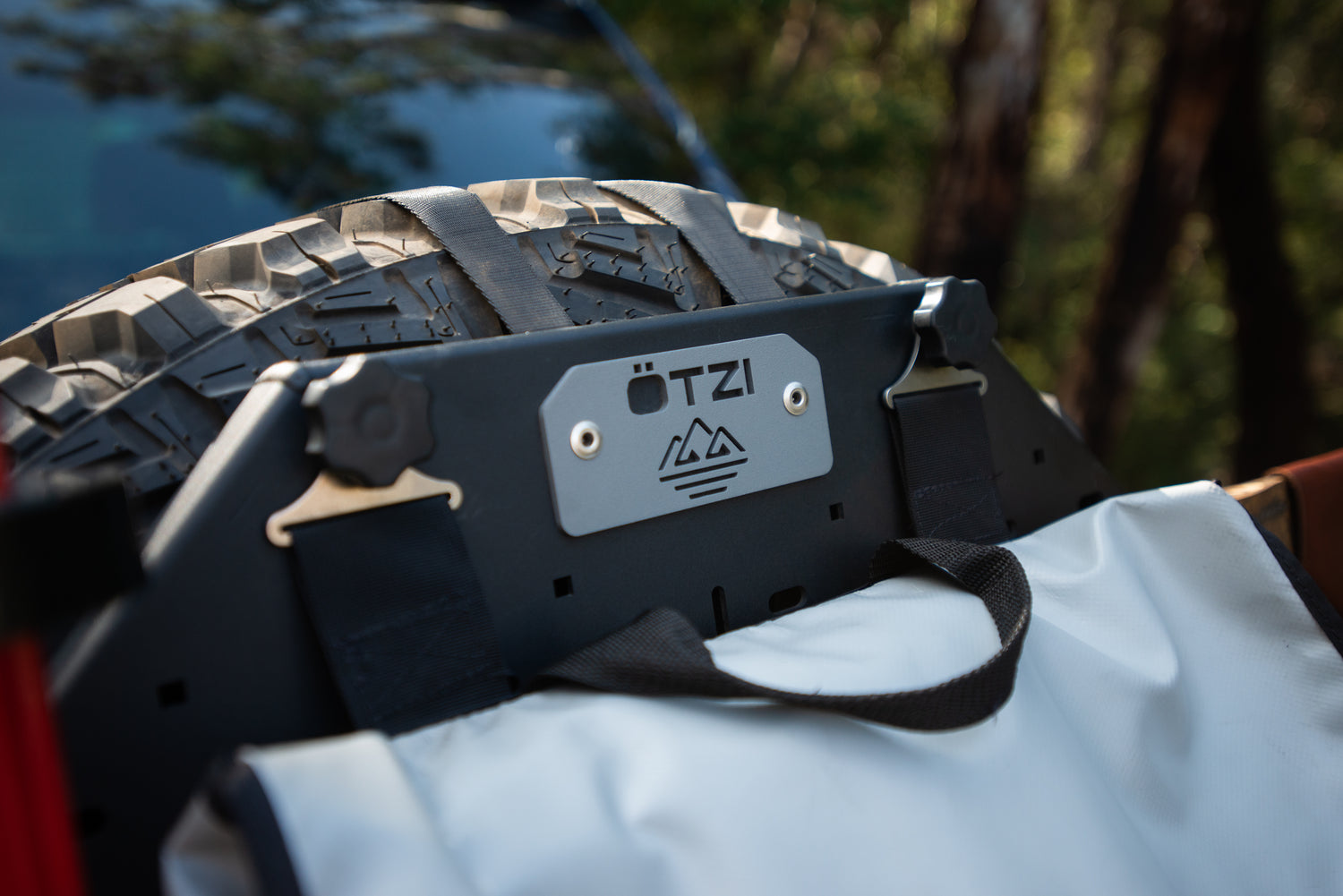 Close-up of an Ötzi gear mount attached to a spare tire on an off-road vehicle.
