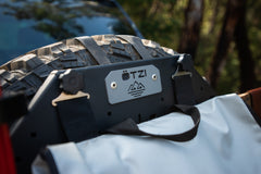 Close-up of an Ötzi gear mount attached to a spare tire on an off-road vehicle.