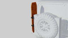 Orange traction board mounted vertically on rear tire carrier of an off-road vehicle