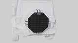 Black octagonal spare tire cover with grid pattern mounted on a white off-road vehicle.